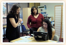 Three woman learning how a device works by touching it