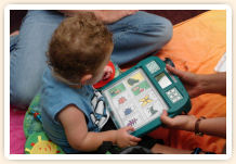A toddler holds a language learning device